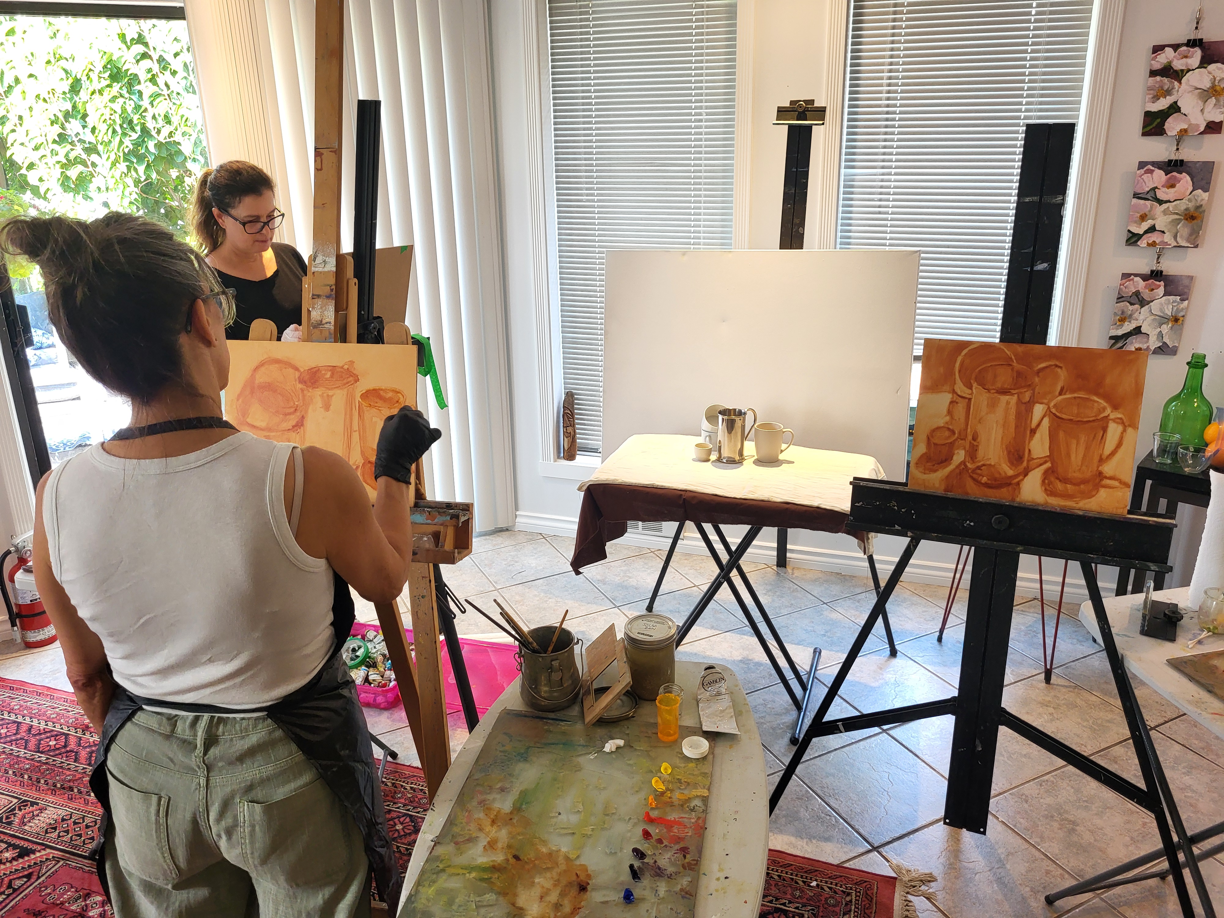 Adult artists painting a still life during a class at The Loft Studio
